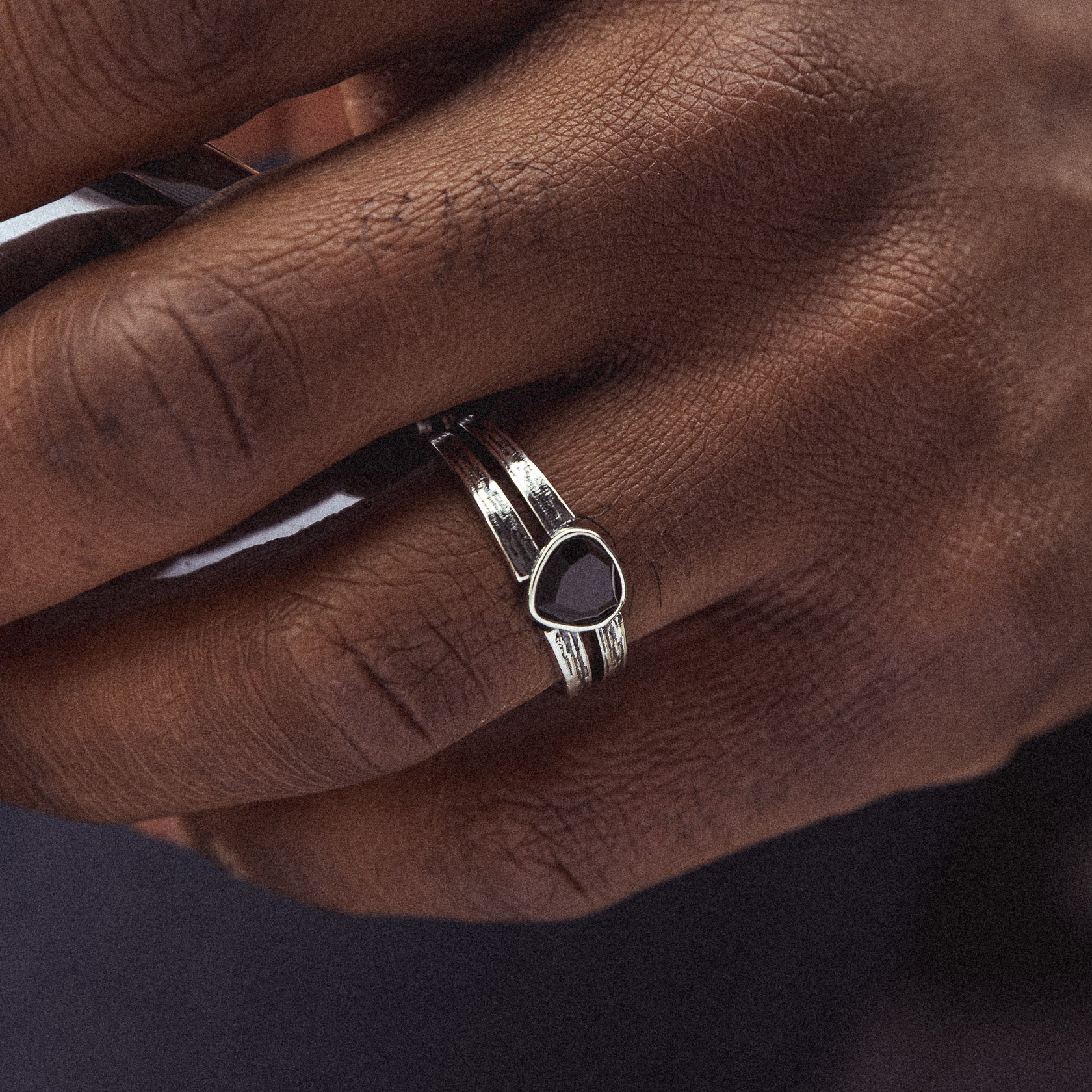 hand wearing sterling silver black onyx black lotus signet ring