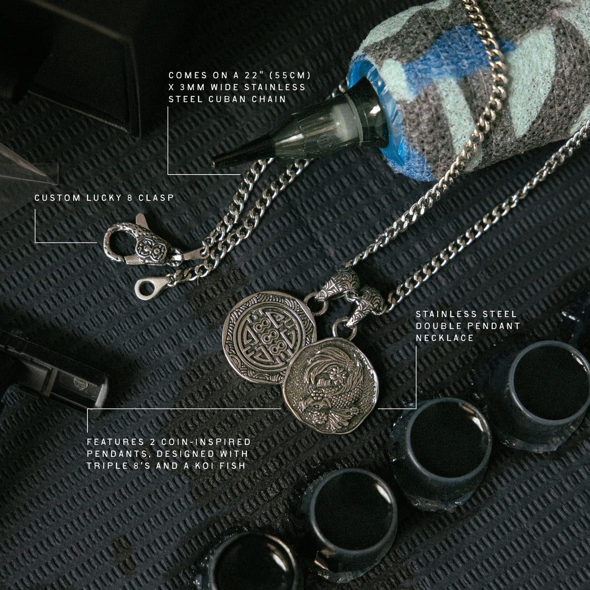 Stainless steel double pendant necklace with coin-inspired charms and 22" Cuban chain, displayed with lucky 8 clasp and black