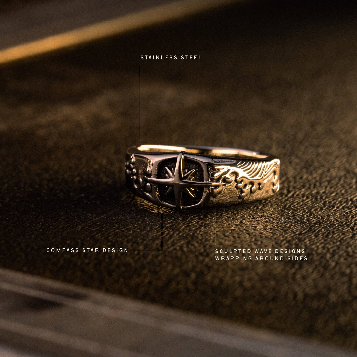 Stainless steel ring with compass star center and sculpted wave designs wrapping around the band.