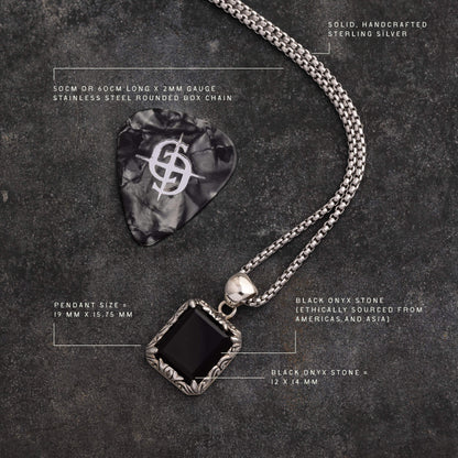 Sterling silver necklace with square black onyx pendant and stainless steel chain on dark textured background.