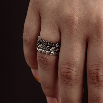 Silver stacked ring with textured and twisted bands worn on ring finger.