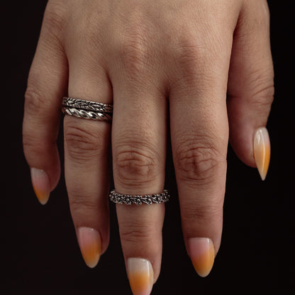 Two textured silver bands worn on fingers with almond nails featuring amber and cream gradient tips.