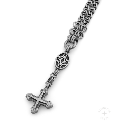 Silver-toned stainless steel chain necklace with decorative oval pendant and cross charm.