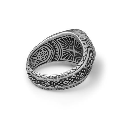 Silver skull ring with intricate patterns on a white background