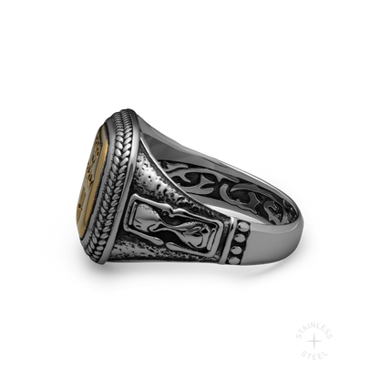 Silver and gold-tone stainless steel signet ring with oval face, ornate band details, and textured bezel.