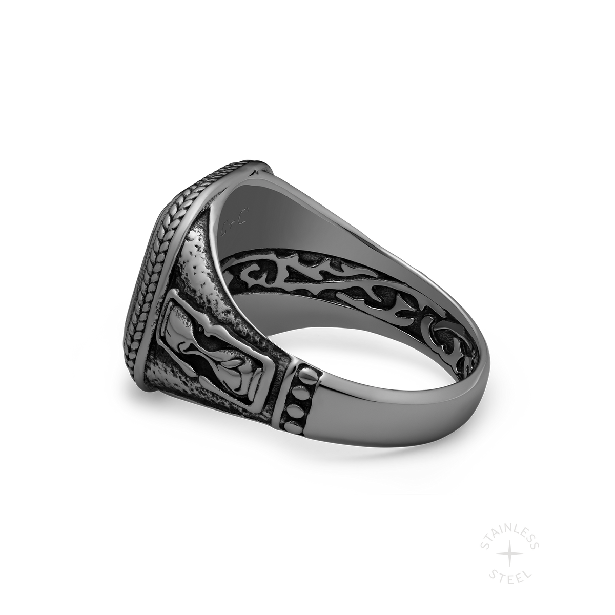 Ornate silver-toned ring with detailed filigree patterns and textured band, shown at an angle on white background.