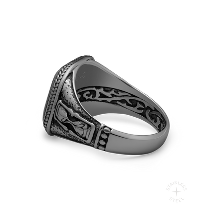 Ornate silver-toned ring with detailed filigree patterns and textured band, shown at an angle on white background.